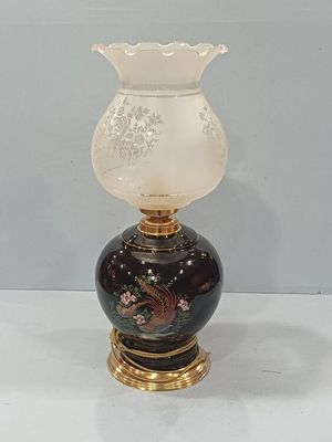 un vase noir et blanc avec un socle doré posé sur une table