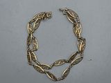 a close up of a gold bracelet on a white surface