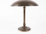 a brass table lamp with a dome shade on a white background