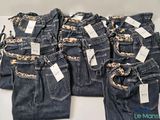 five pairs of jeans with tags on them sitting on a table