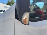 a reflection of a man in the side mirror of a truck