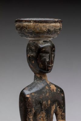 un gros plan sur la statue d'une femme portant un bol sur la tête