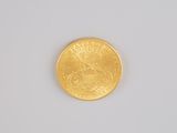 a close up of a gold coin on a white surface