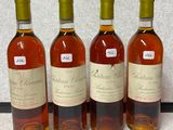 four bottles of wine are lined up on a table