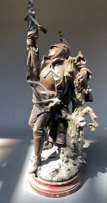 une statue représentant un homme tenant un couteau et un oiseau