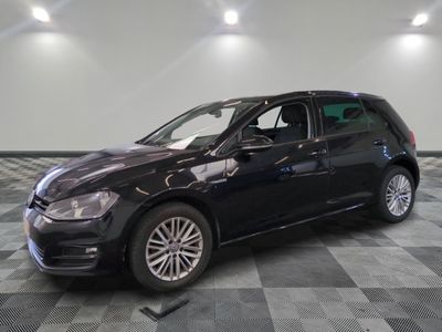 the black volkswagen golf is parked on a checkered tile floor
