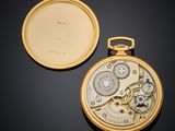 an image of a gold pocket watch with a white dial and a black background