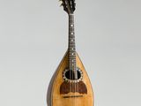 une vieille mandoline en bois posée sur un plan de travail blanc