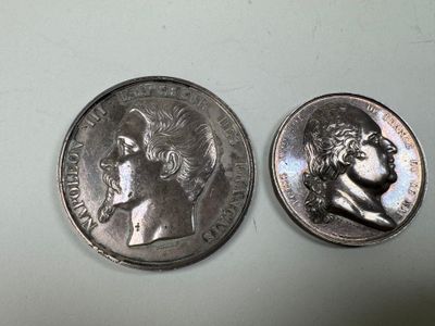 two silver coins with a portrait of a man and a woman on them