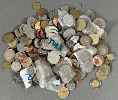 une pile de pièces et une bouteille d'eau posées sur une table