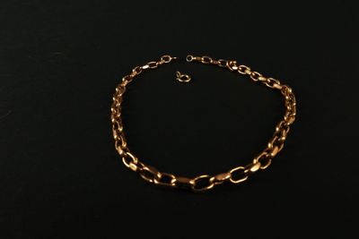 un bracelet en chaîne en or sur fond noir