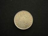 a small coin on a black surface with a black background