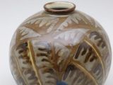 a brown and blue vase sitting on a white surface