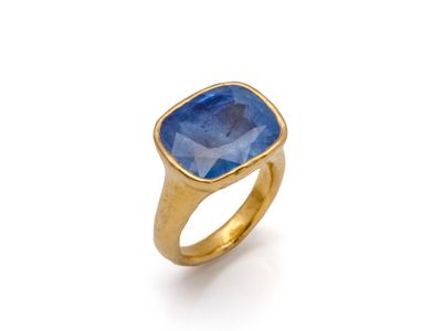 une bague en or avec une pierre bleue au centre