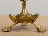 a gold colored candle holder with a bird on top of it