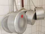 des casseroles et des poêles suspendues à une étagère dans une cuisine