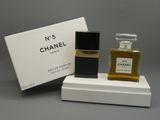 a bottle of chanel perfume sitting on top of a white box