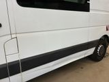 a white van with a black stripe parked in a garage