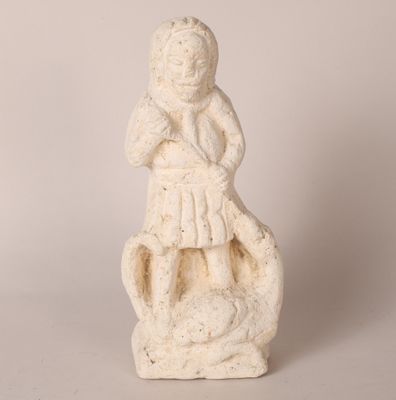 statue d'une femme assise sur un rocher, les bras croisés