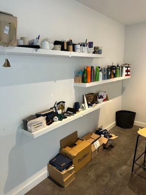 a room with a desk, shelves, and a chair in it