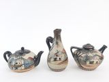 three teapots that are sitting on a white surface