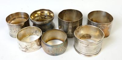 Plusieurs coupes en argent sont disposées en cercle sur une surface blanche