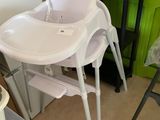 a baby high chair in the corner of a room