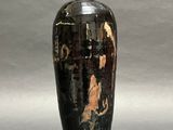 a black and gold vase sitting on a gray surface