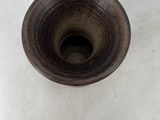 a brown vase sitting on a white surface with a white background