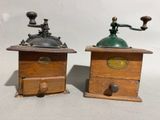 pair of antique coffee grinders on wooden bases with brass knobs