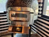 an image of a pizza oven in the corner of a room