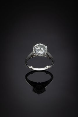 gros plan d'une bague en diamant sur une surface noire