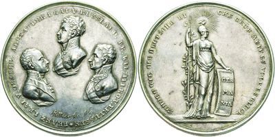 a close up of two silver coins with a statue on them