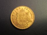a close up of a gold coin on a black surface