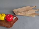 two apples on a cutting board and a knife on a cutting board