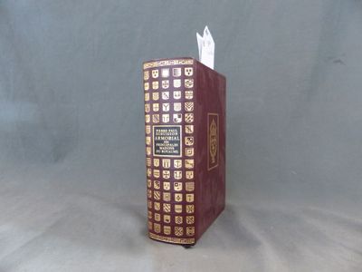 un livre rouge orné de motifs dorés et blancs