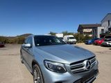 a silver mercedes gle parked in a parking lot next to a house