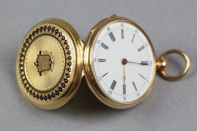 une montre de poche en or avec des chiffres romains