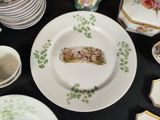 many plates and cups on a table with a black table cloth
