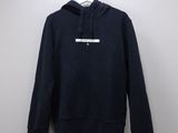 a black hoodie hanging on a hanger against a white wall