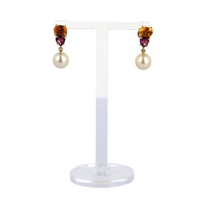 an image of a pair of earrings with pearls on a stand