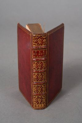 a red book with gold trim sitting on a table
