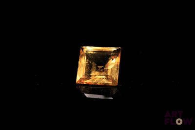 un gros plan d'un diamant jaune carré sur fond noir