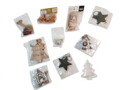 de nombreuses décorations de Noël dans des sachets, posées sur une surface blanche