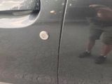 a reflection of a man in the door of a car