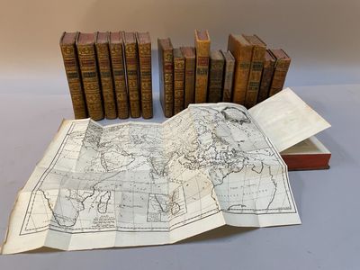 une vieille carte du monde sur une table à côté d'une pile de livres