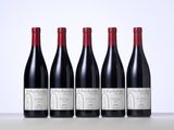 four bottles of wine are lined up on a table