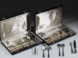 des couverts dans un coffret posé sur une table contenant d'autres couverts