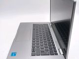 a silver laptop with a black keyboard on a white surface