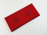 a red object on a white surface with two holes in it